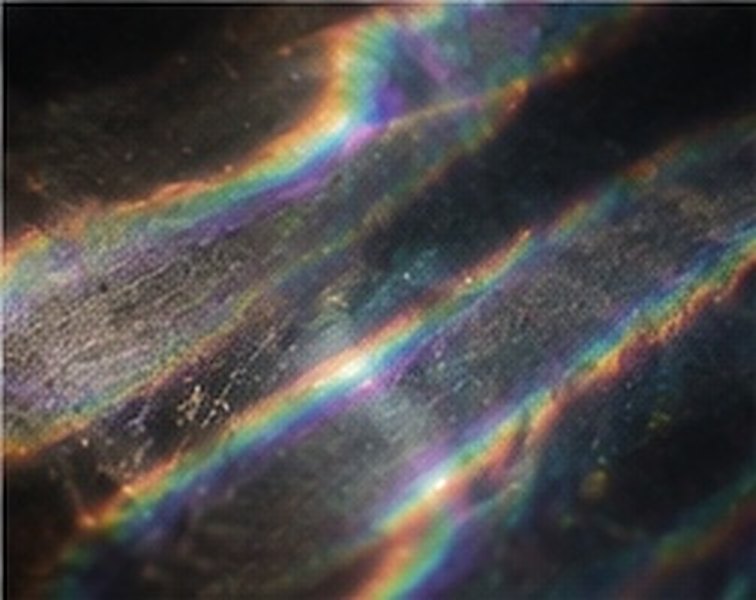 Streaks of refracted rainbow light across a dark surface